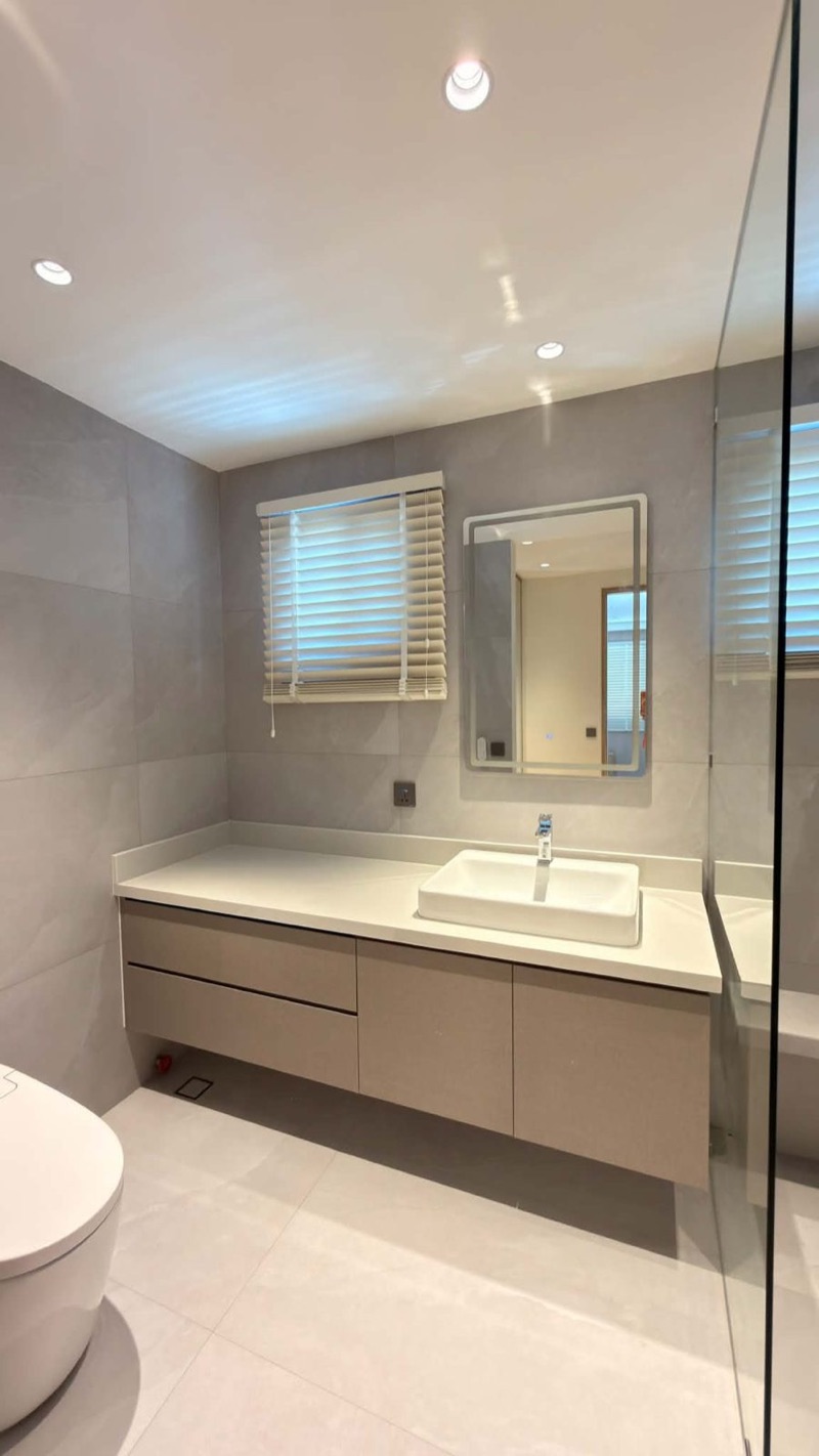 Floating bathroom vanity with a stone top and a window above