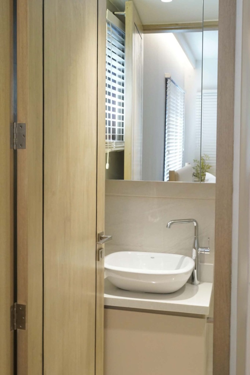 Compact vanity with a vessel sink beside an oak-framed door