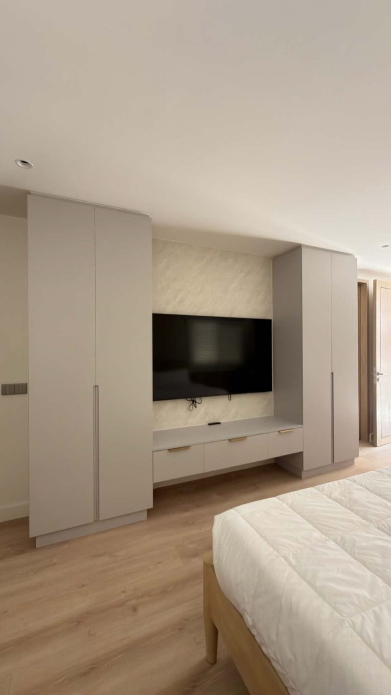 Bedroom with wardrobes on both sides of a TV console