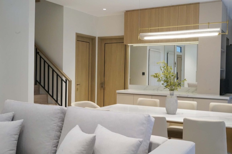 Living and dining room with an oak-and-greige sideboard and a mirrored splash