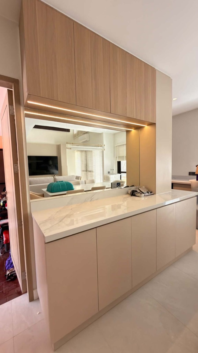 Pantry sideboard with oak upper cabinets, a mirror splash and greige base cabinets