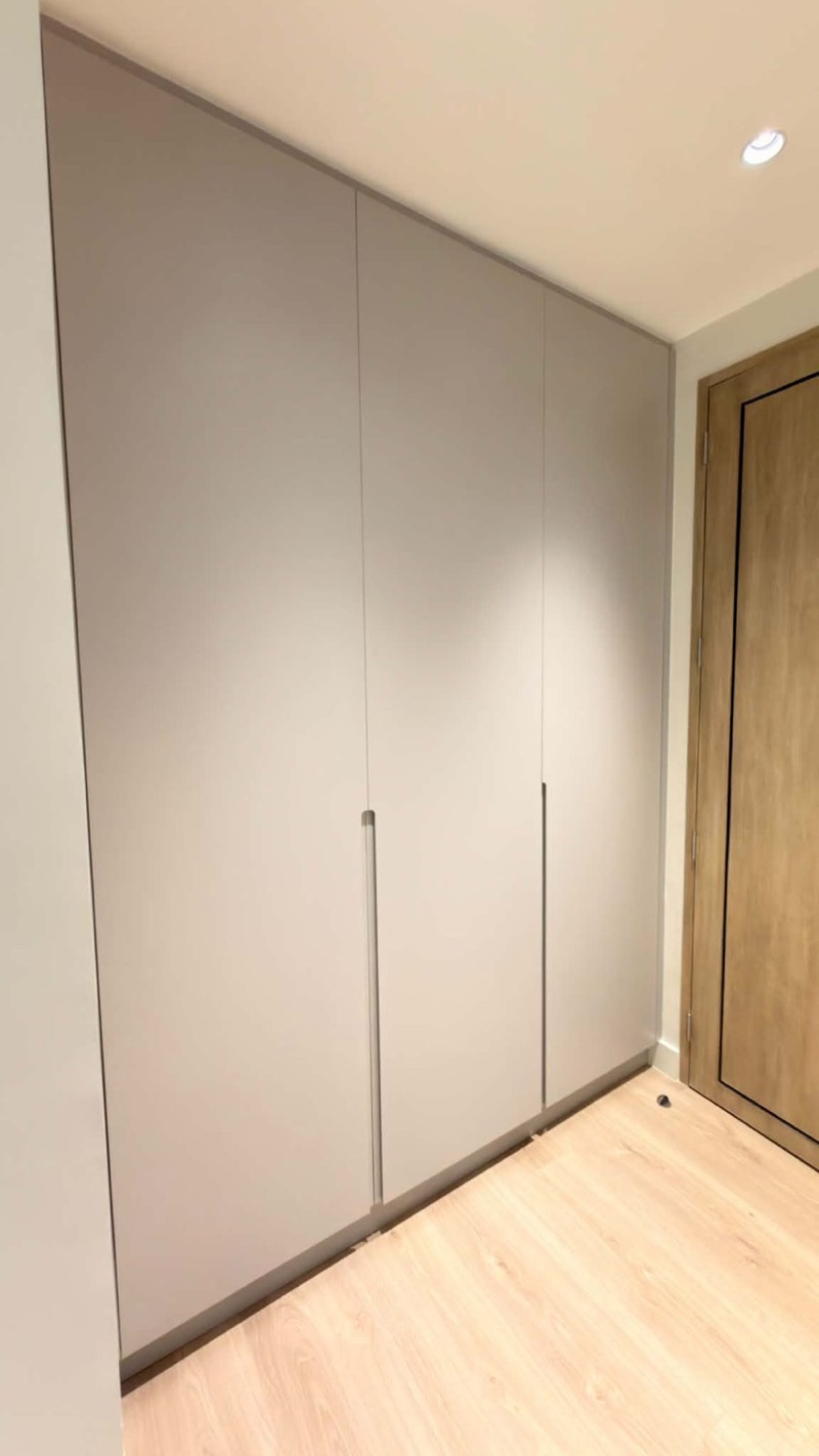 Floor-to-ceiling greige wardrobe with slim recessed handles