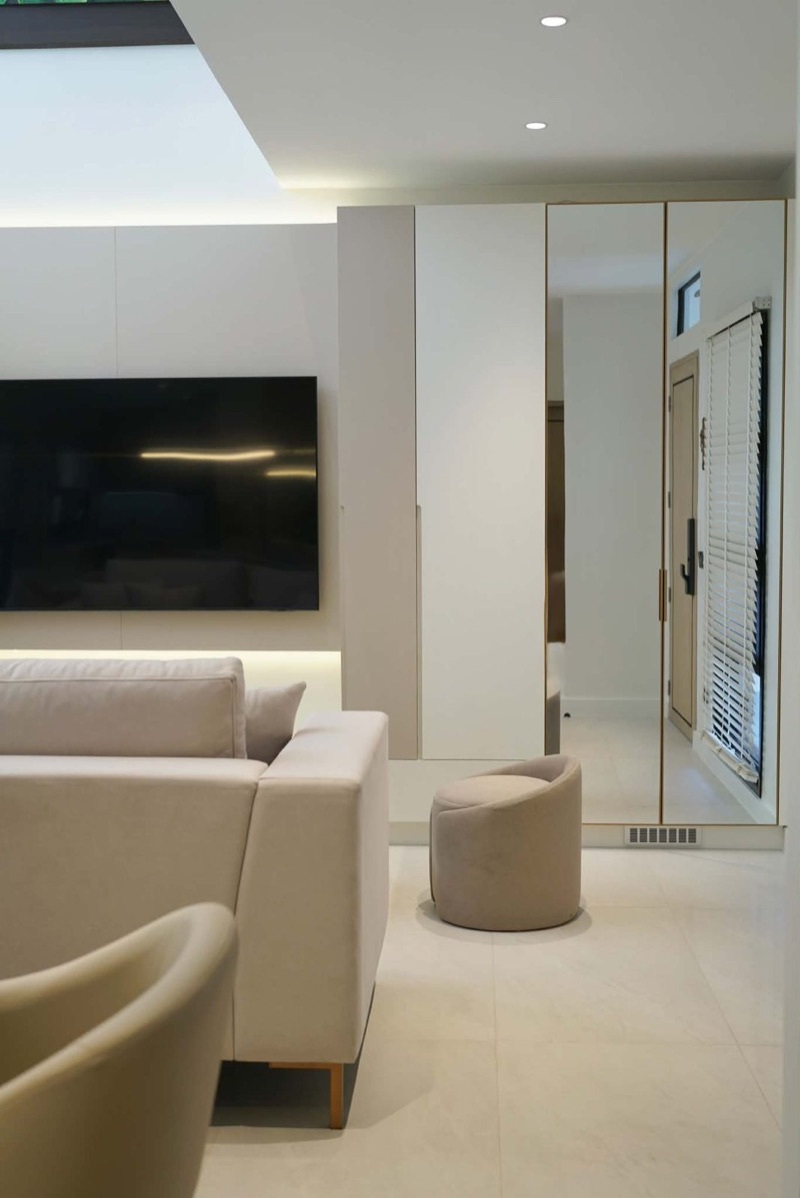 Lounge area with a tall mirrored wardrobe beside the TV wall
